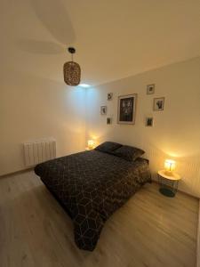 ein Schlafzimmer mit einem Bett und zwei Tischen mit Lampen in der Unterkunft Le beauvais in Évron