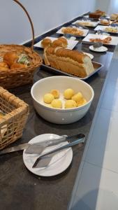 a table with a plate of food and baskets of bread at Hotel Pintado Azul in Coxim