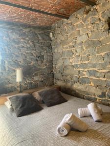 sypialnia z 2 łóżkami i kamienną ścianą w obiekcie Dailly studio w mieście Dailly