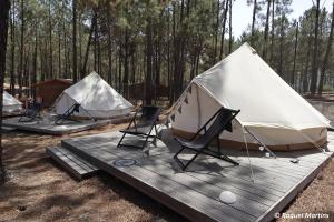 três tendas e cadeiras num deque de madeira em Odeceixe Bungalow-Parque de Campismo Sao Miguel em Odeceixe