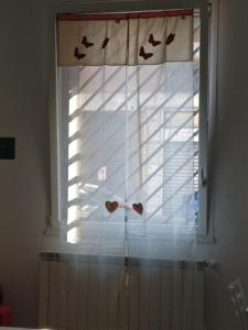 a window with butterflies on it with a window shade at Maison Jolie in Rho