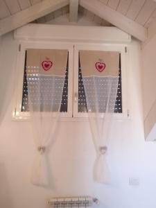 a kitchen window with curtains with hearts on it at Maison Jolie in Rho