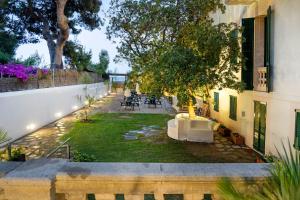 a garden with a table and chairs in a yard at Kalima Beach in Caldes d'Estrac