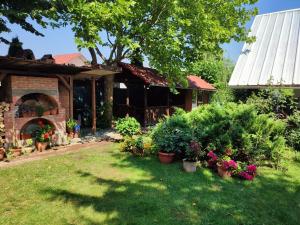 un cortile con fiori e piante di fronte a una casa di Pensiunea Anita a Haţeg
