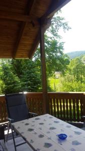 einen Tisch und einen Stuhl auf einer Veranda mit Aussicht in der Unterkunft Ferienhaus "Am Schleifenbach" in Saalfeld