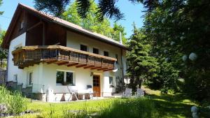 uma casa com uma varanda ao lado em Ferienhaus "Am Schleifenbach" em Saalfeld