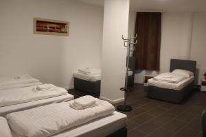um quarto com três camas e uma tv nele em David's Hostel em Geesthacht