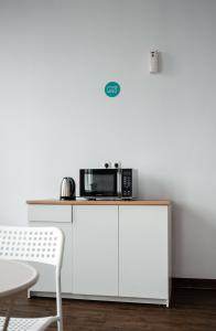 a microwave sitting on top of a white cabinet at Bobopod Kota Tua, Jakarta in Jakarta