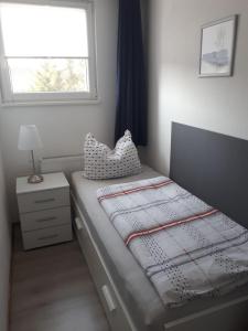 ein kleines Schlafzimmer mit einem Bett und einem Fenster in der Unterkunft Apartement Meerblick in Wunstorf