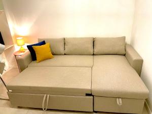 Happy Casa Isola Piccola في إيزولا: أريكة في غرفة معيشة مع وسادة صفراء