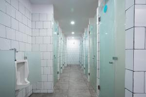 a corridor of a bathroom with urinals and a urinal at Bobopod Kota Tua, Jakarta in Jakarta