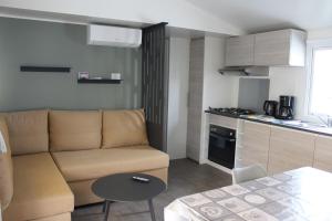 uma sala de estar com um sofá e uma cozinha em Vos meilleures vacances au Montourey! em Fréjus