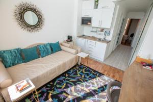 uma sala de estar com um sofá e uma cozinha em FABULOUS !!APARTMENT A FRONT OF LEGENDARY MONTE CARLO BEACH and TENNIS CLUB ! em Roquebrune-Cap-Martin