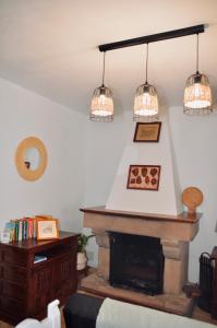 uma sala de estar com três luzes penduradas sobre uma lareira em Apartamento Hiedra em Santillana del Mar