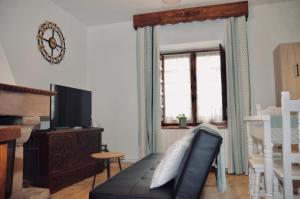 a living room with a couch and a television at Apartamento Hiedra in Santillana del Mar