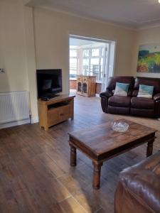 sala de estar con sofá y TV en The Denes, en Mablethorpe