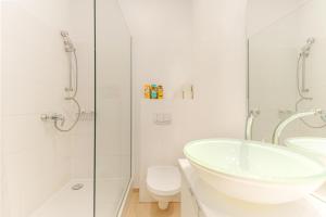 a white bathroom with a sink and a toilet at Luxurious and Bright, 5 min to city center in Vienna