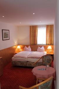 a hotel room with a bed and a table at Gasthaus& Pension Zum Roten Haus in Bad Schandau