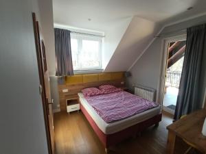 ジェロナ・グラにあるNoclegi Zielona Góra u Moniのベッドルーム(紫色の掛け布団付きのベッド1台付)