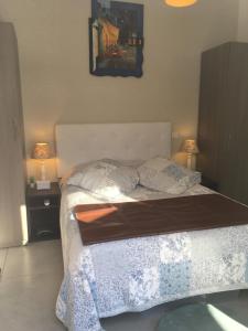 a bedroom with a bed and two night stands with lamps at Bastidon des Alpilles 11 in Saint-Rémy-de-Provence