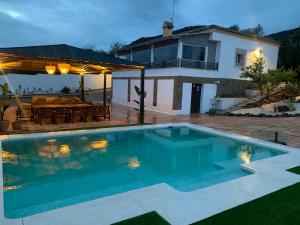 a villa with a swimming pool in front of a house at El Rincón del Brillante in Córdoba