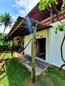 a house with a hammock outside of it at ITACUPA - Healthy VEGAN & FOIL Center in Cumbuco