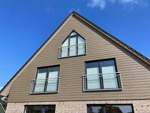 a house with three windows on the side of it at Ragnar Maisonette in Büsum
