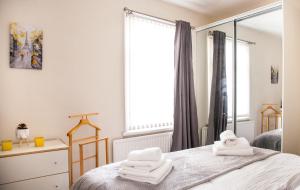una camera da letto con asciugamani bianchi su un letto con specchio di Contractor house, sleeps 5, close to restaurant's and bars, Long stays available, Oveyo Accommodation a Middlesbrough