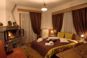 1 dormitorio con 1 cama con toallas en La Petri Studios with Fireplace & View, en Metsovo