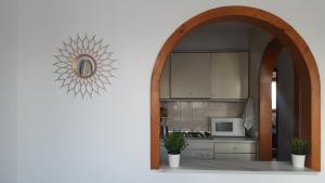 einen Torbogen, der in eine Küche mit einer Mikrowelle führt. in der Unterkunft Apartamento bungalow in Mojácar
