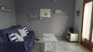 ein Wohnzimmer mit einem blauen Sofa und einem Tisch in der Unterkunft Apartamento bungalow in Mojácar