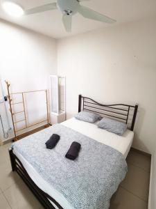a bedroom with a bed with two black slippers on it at TuR11-Oppesite Pisa Stadium-1min-FoodCourt-MiniMarket in Bayan Lepas