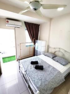 a bedroom with a bed with two black shoes on it at TuR11-Oppesite Pisa Stadium-1min-FoodCourt-MiniMarket in Bayan Lepas