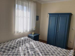 - une chambre avec un lit, une armoire bleue et une fenêtre dans l'établissement Darsser Weg 32, à Zingst