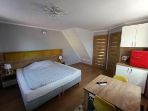 a bedroom with a bed and a table in it at Noclegi Zielona Góra u Moni in Zielona Góra
