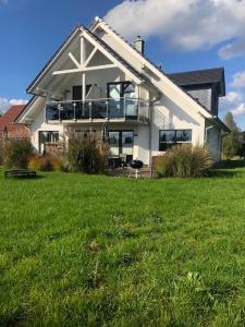 ein großes weißes Haus mit Rasen davor in der Unterkunft Haus Hannah in Ostseebad Sellin