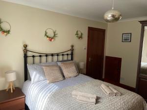 a bedroom with a bed with two towels on it at Craigavon Cottage in Ballachulish