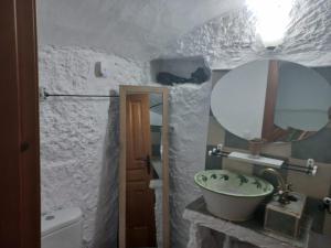 Cuevas Barrio Las Santas في هويسكار: حمام مع حوض ومرآة