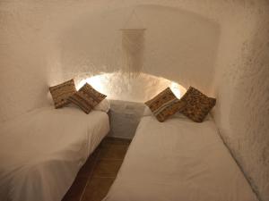 Cuevas Barrio Las Santas في هويسكار: غرفة بسريرين في غرفة بجدار