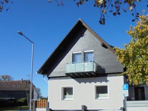 ein weißes Haus mit einem Balkon in der Unterkunft Ferienwohnung Mara in Steinhude