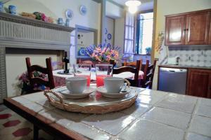 a table with cups and saucers on it in a kitchen at VILLA PANDOLFINI 1 in Lastra a Signa