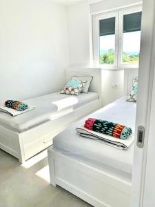 2 camas en una habitación con 2 ventanas en Brand new 3 bedroom apartment Inara G, en Nin