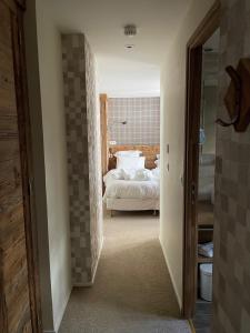 a bedroom with a white bed and a bathroom at Hotel La Toviere in Val dʼIsère