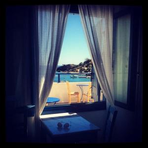 a room with a window with a view of the ocean at Sofia Rooms in Loutro