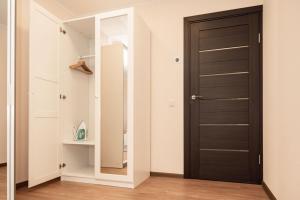 a hallway with a black door and a mirror at Crown Apartment City Center in Ukmergė