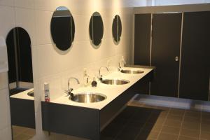 a bathroom with two sinks and mirrors on the wall at Apartment Nieuw-Moscou in Hollandscheveld