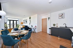 eine Küche und ein Wohnzimmer mit Tisch und Stühlen in der Unterkunft Spacious Designer 2BR Executive Apt, Near Beach & Marina, Central Location in Kent