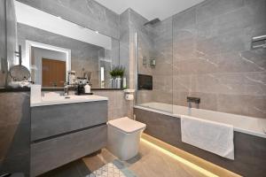 ein Badezimmer mit Waschbecken, Badewanne und Toilette in der Unterkunft Spacious Designer 2BR Executive Apt, Near Beach & Marina, Central Location in Kent + 99 Fotos