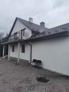 Casa bianca con balcone e tavolo di Apartament u Wioli a Okleśna