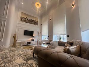 uma sala de estar com um sofá e uma televisão em Alojamiento Santa Teresa em Alba de Tormes